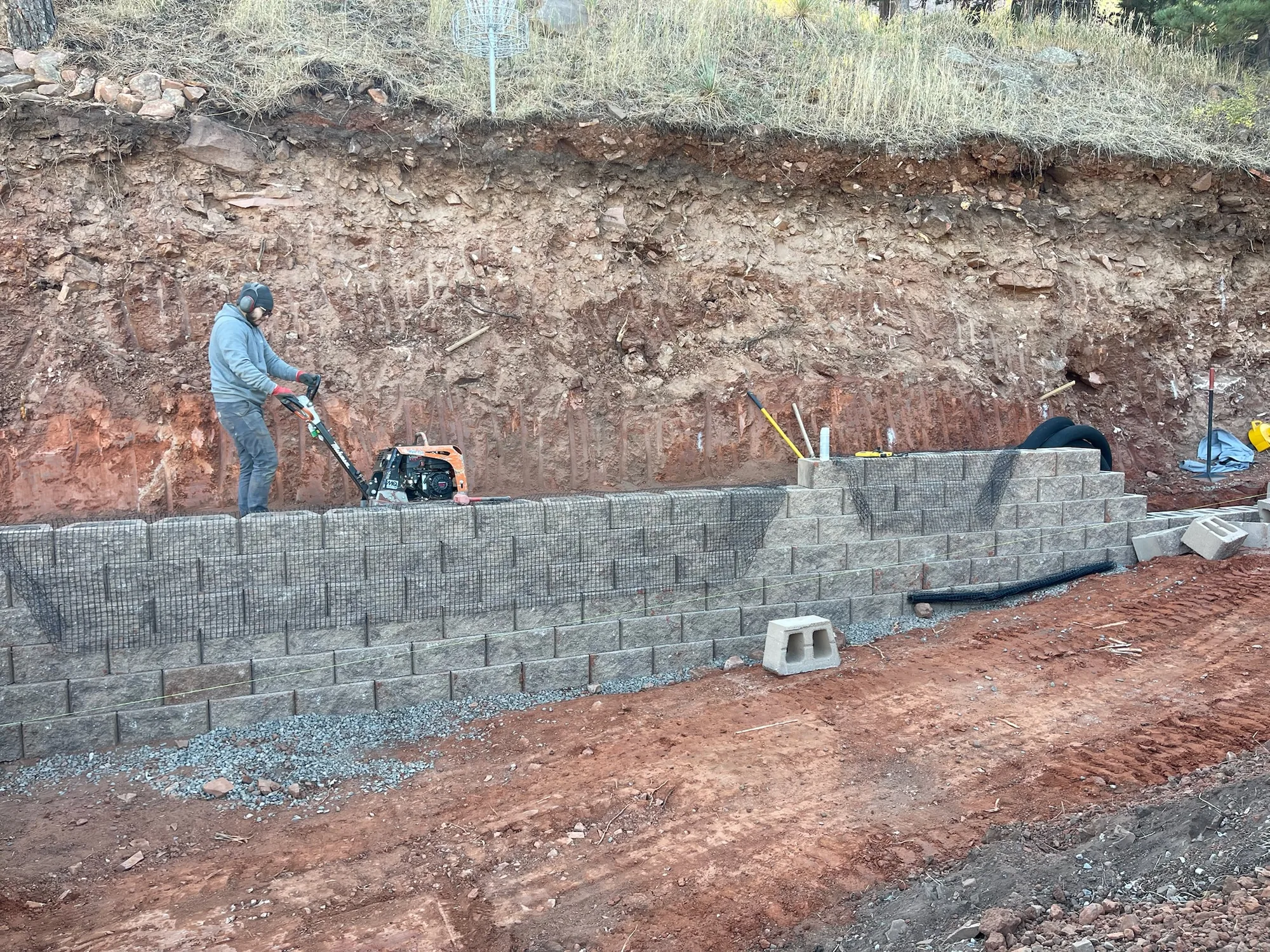 Segmental retaining wall under construction on a steep slope