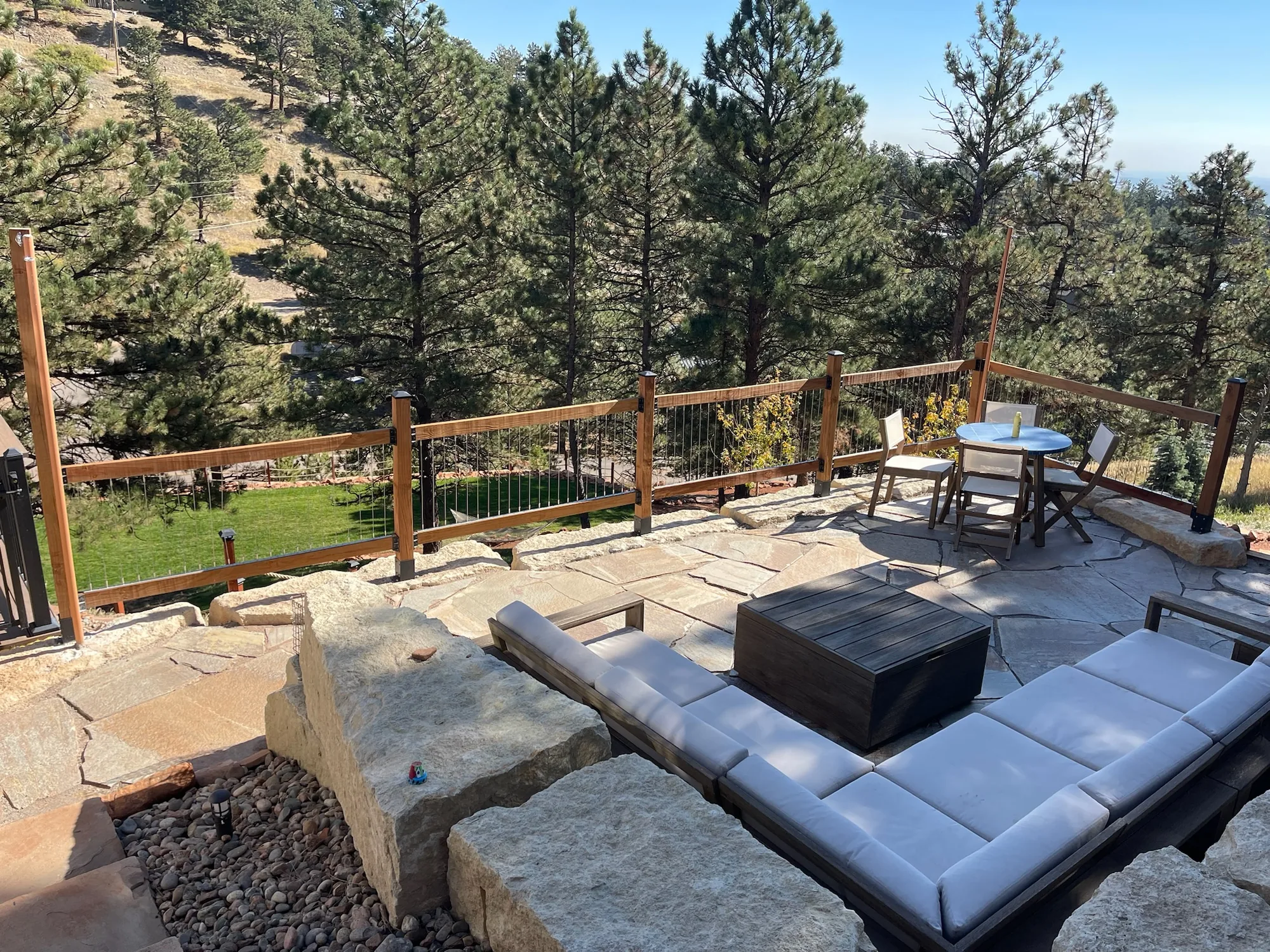 Hillside lounge area framed by boulders and timber railing