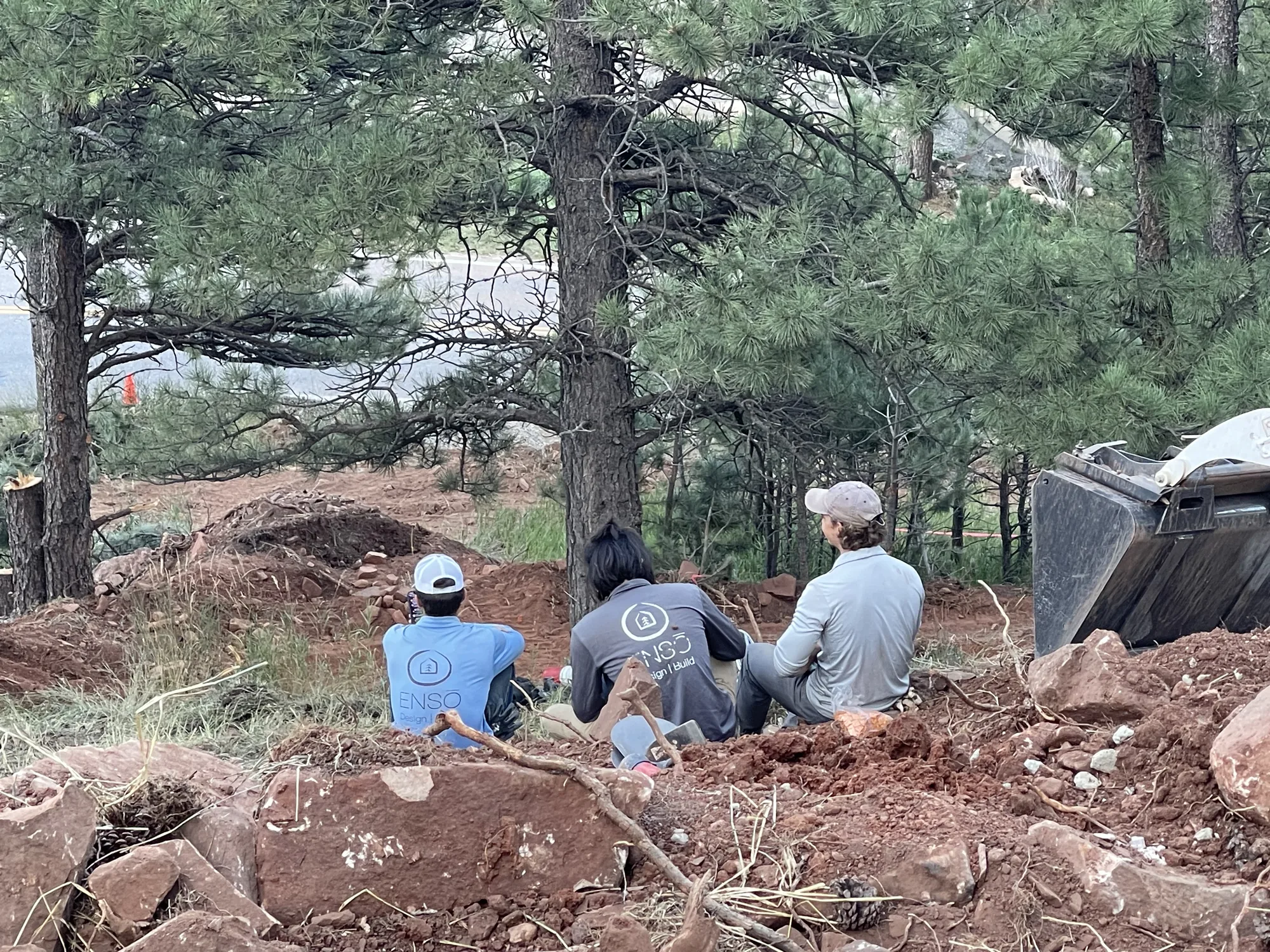 Crew installing landscape infrastructure on a wooded slope