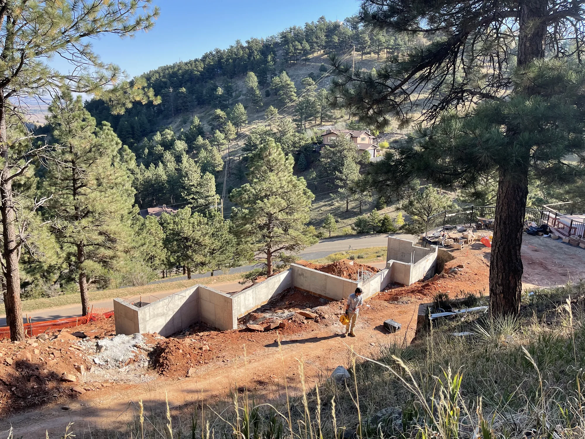 Concrete foundations stepping down a wooded mountain slope