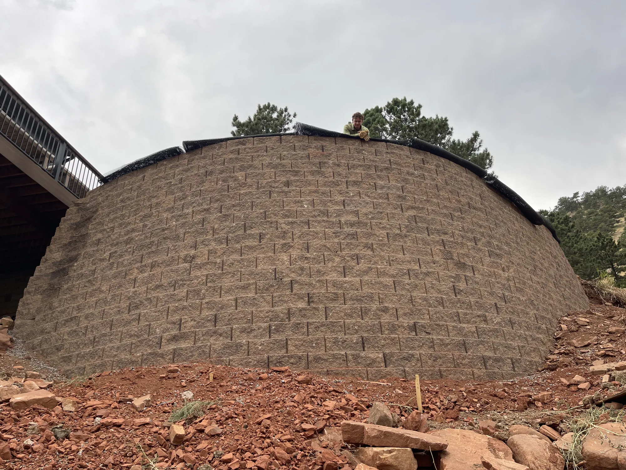 Large curved retaining wall under construction on a sloped site