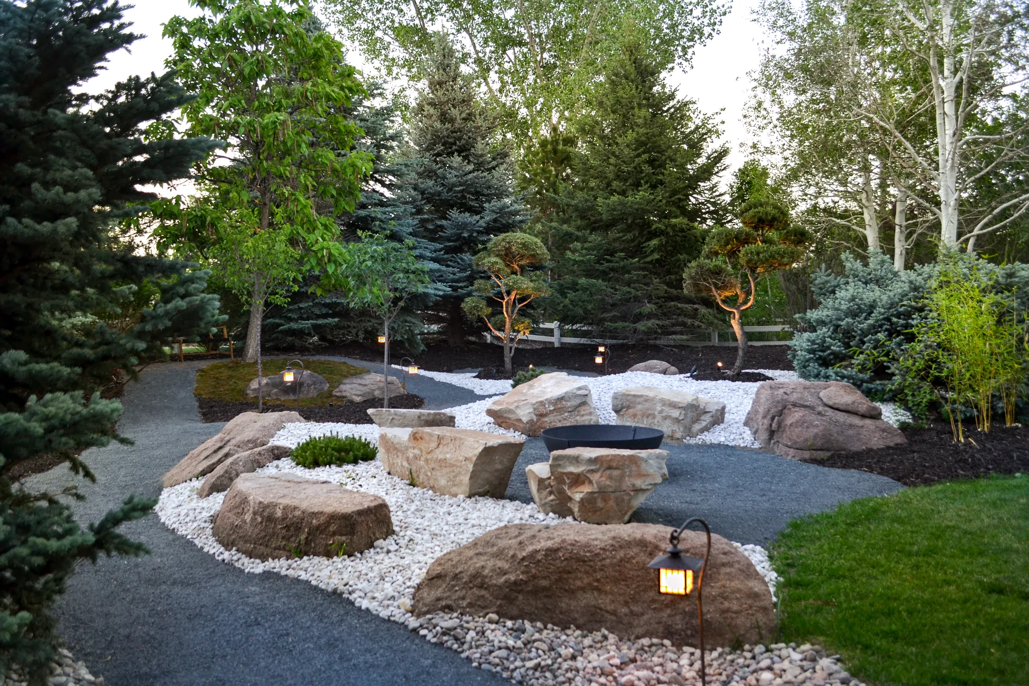 Curving gravel paths through boulder seating and planting