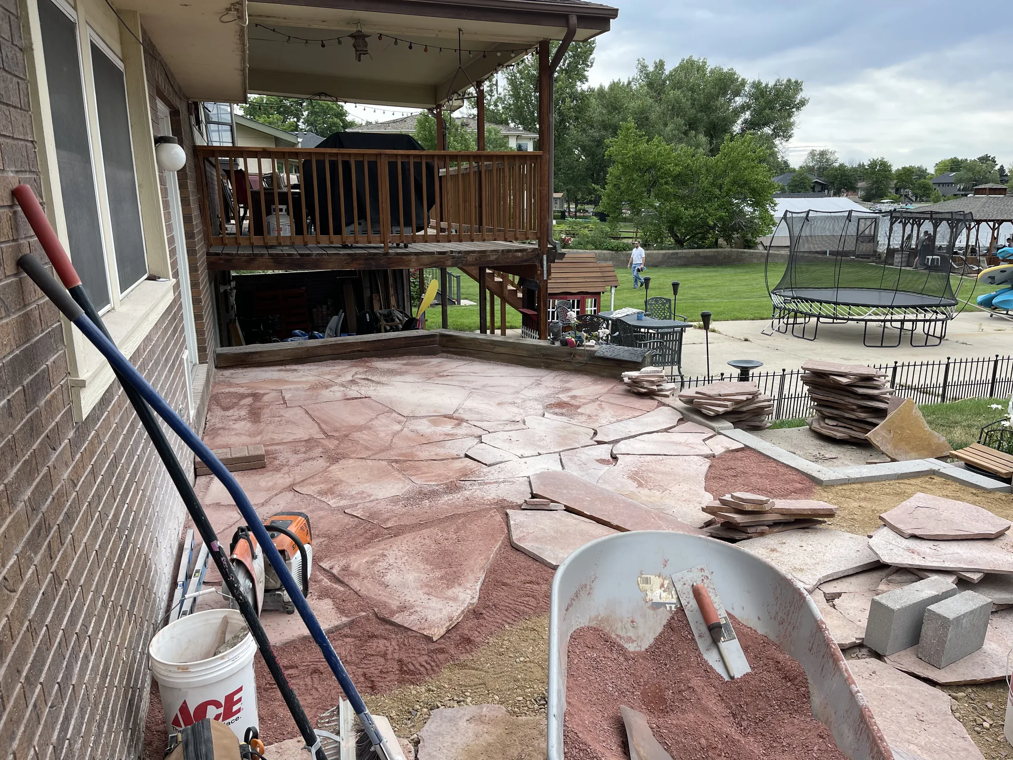 Flagstone patio construction beside an existing deck