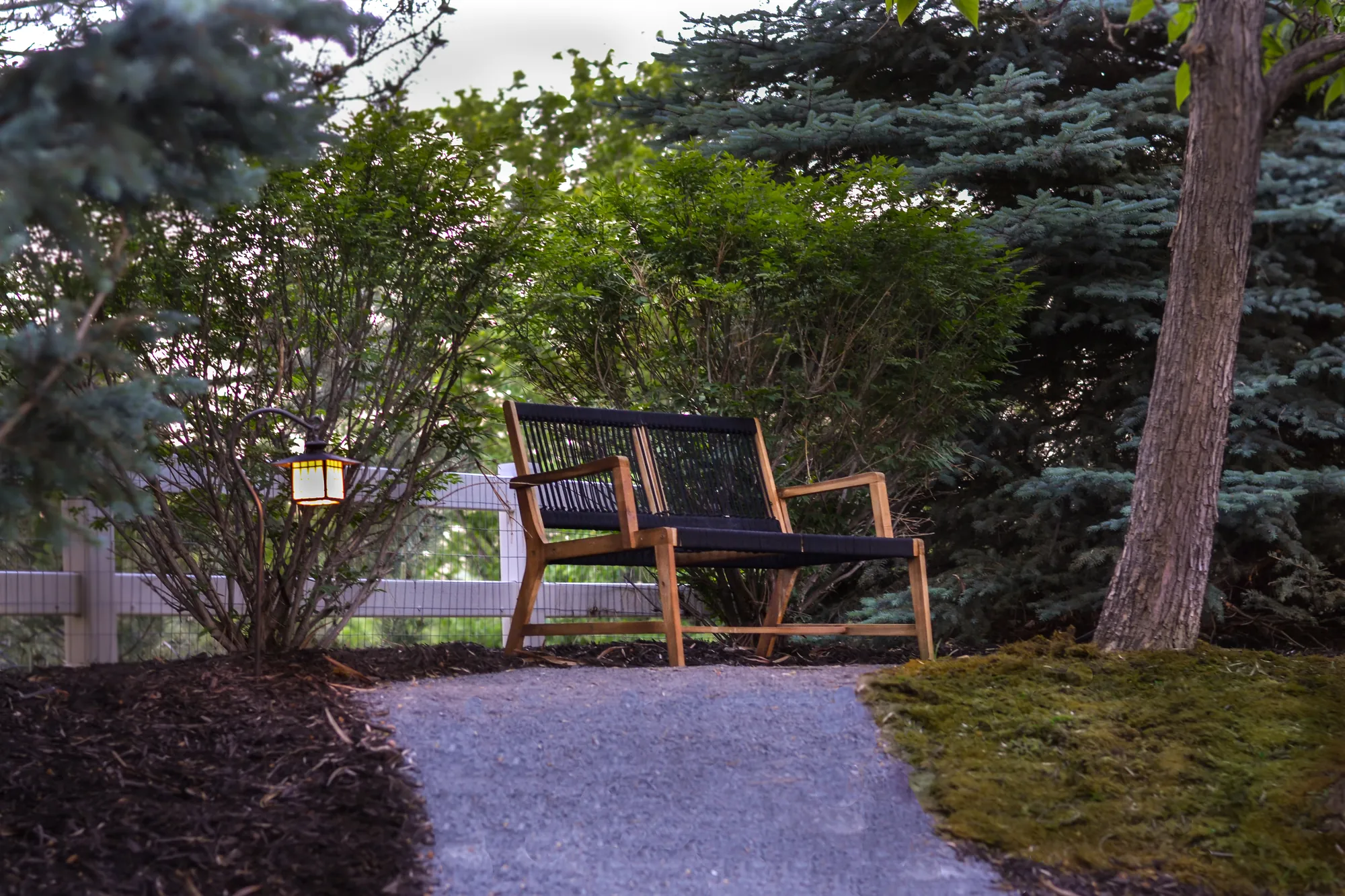Bench at the end of a gravel path within Treestead Retreat